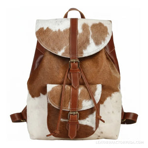 Brown and white hair-on cowhide drawstring backpack – front view with buckle flap and pocket