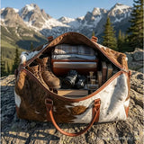 Brown and white hair-on cowhide duffle bag – packed for a weekend trip