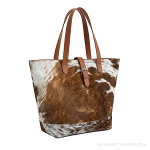 Brown and white hair-on cowhide tote bag – front view with buckle strap